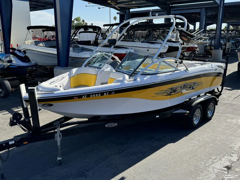 Slide: The Image of 2007 Nautique SV211 boat with yellow accents on a trailer in a marina. - 11