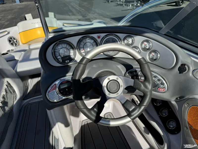 Slide: The Image of 2007 Nautique SV211 boat dashboard with steering wheel and instrument panel. - 2