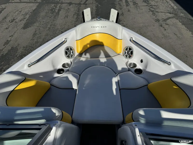 Slide: The Image of 2007 Nautique SV211 boat interior with yellow and gray seating, cup holders, and speakers. - 3