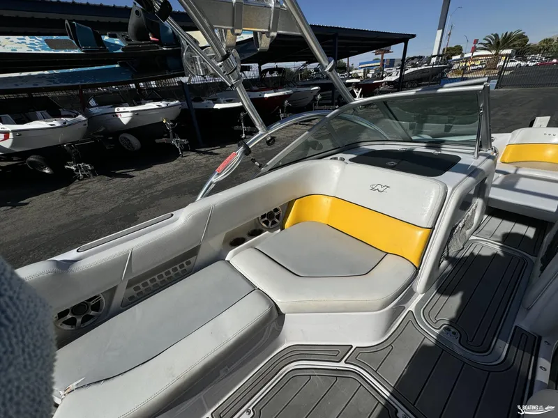 Slide: The Image of 2007 Nautique SV211 boat interior with yellow and white seating, docked at a marina. - 4