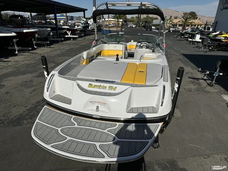 Slide: The Image of 2007 Nautique SV211 boat with yellow accents, parked in a marina. - 9