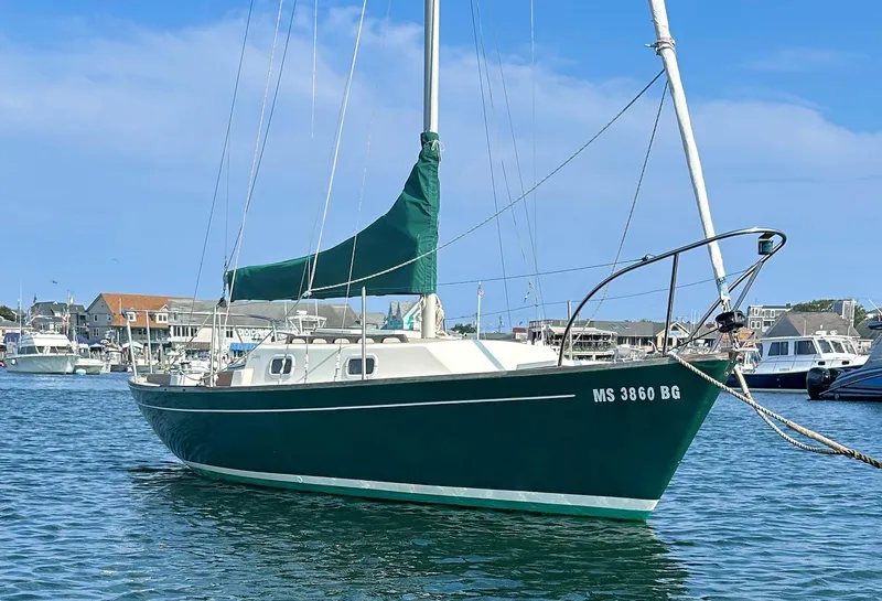 The Image of 1988 Quickstep 24 sailboat docked in a marina, featuring a green hull and sail cover. - 0