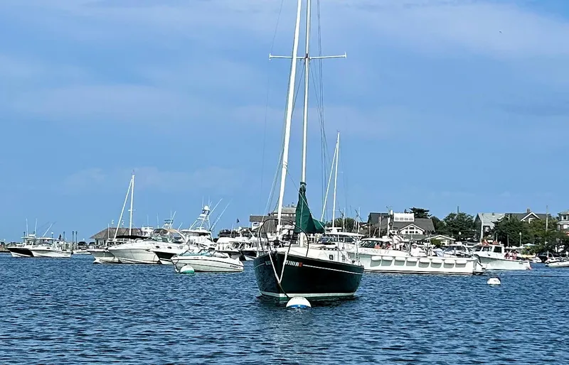 Slide: The Image of Sailboat Quickstep 24 (1988) anchored in a bustling marina under a clear blue sky. - 2