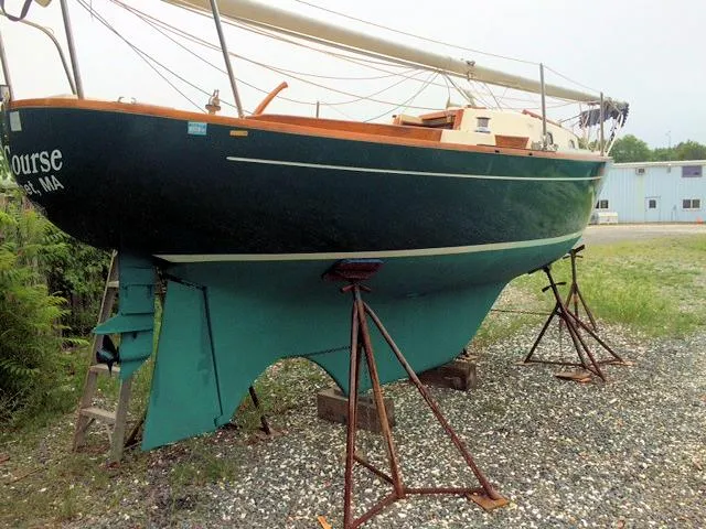 Slide: The Image of 1988 Quickstep 24 sailboat on stands, green hull, outdoor setting. - 3