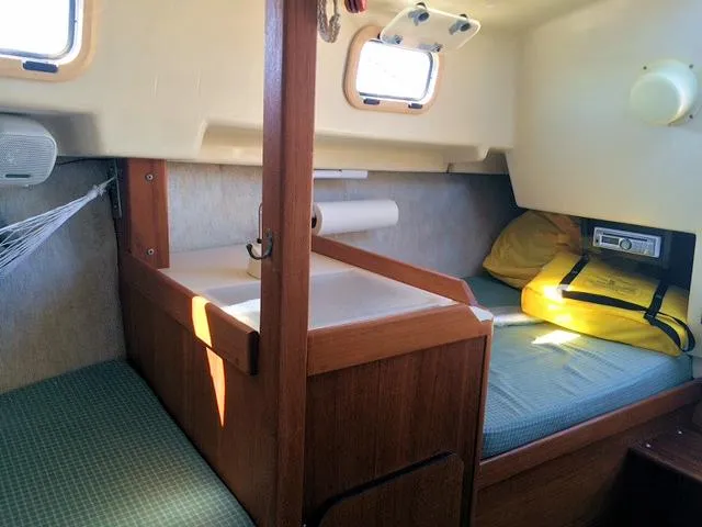 Slide: The Image of 1988 Quickstep 24 sailboat interior with cozy sleeping area and wooden cabinetry. - 9