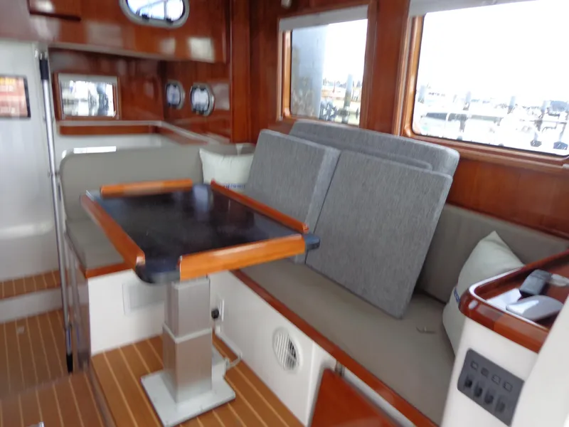 Slide: The Image of 2020 SeaPiper Pilothouse interior with wooden accents and cushioned seating. - 14