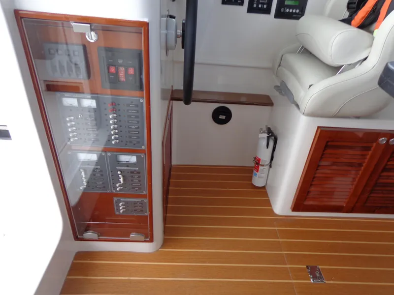 Slide: The Image of 2020 SeaPiper Pilothouse interior with control panel, wooden flooring, and white seating. - 16