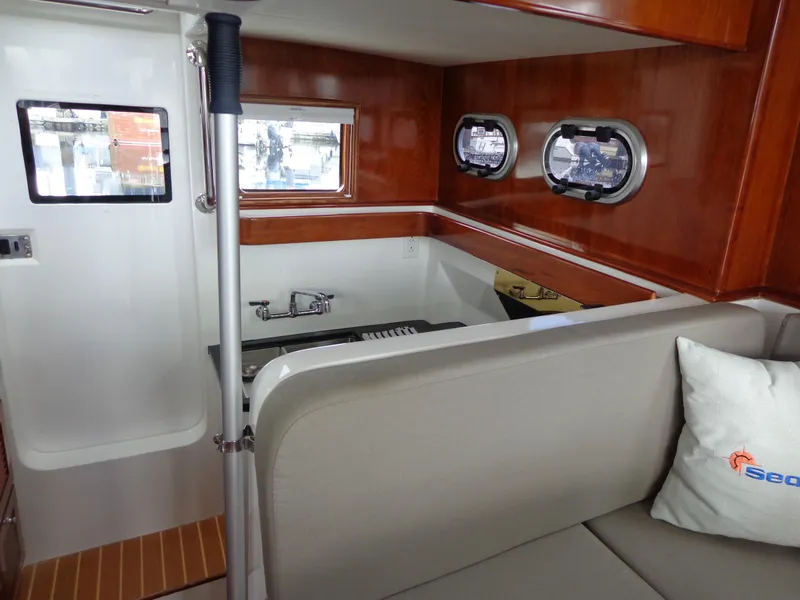 Slide: The Image of Interior of 2020 SeaPiper Pilothouse with wood finish and seating area. - 17