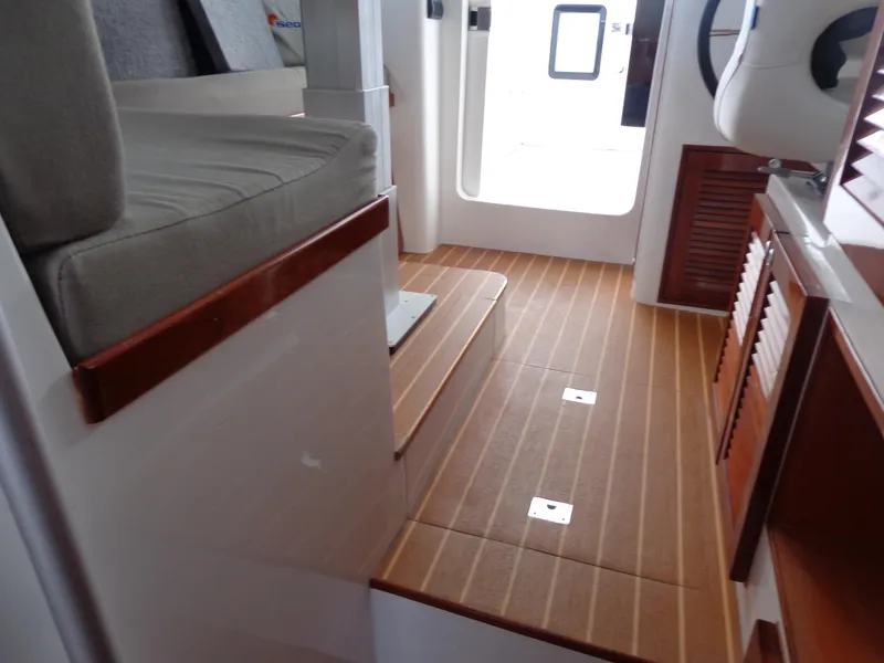 Slide: The Image of Interior of 2020 SeaPiper Pilothouse with wooden flooring and seating area. - 21