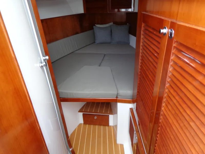 Slide: The Image of 2020 SeaPiper Pilothouse interior with wooden finish and cozy sleeping area. - 26