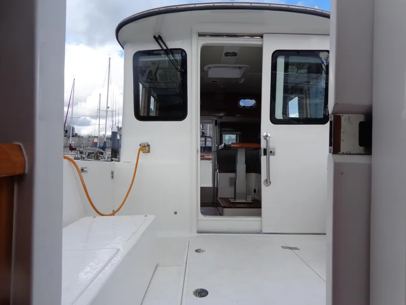 Slide: The Image of 2020 SeaPiper Pilothouse boat interior with open doors and visible seating area. - 29