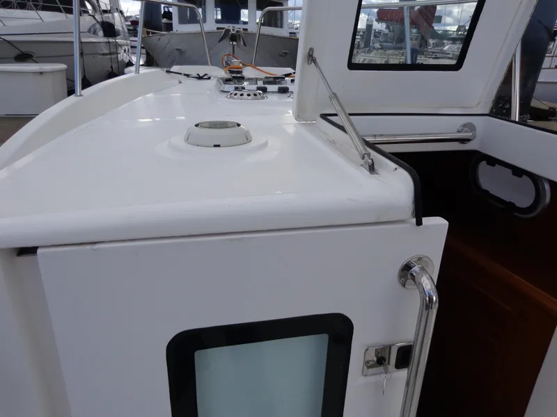 Slide: The Image of 2020 SeaPiper Pilothouse boat deck with white exterior and windowed cabin door. - 30
