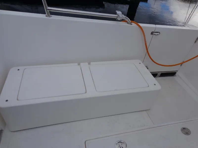 Slide: The Image of 2020 SeaPiper Pilothouse boat deck with storage bench and orange hose. - 31