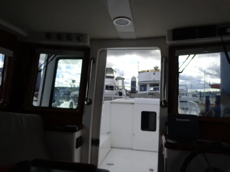 Slide: The Image of Interior view of 2020 SeaPiper Pilothouse with marina in background. - 38