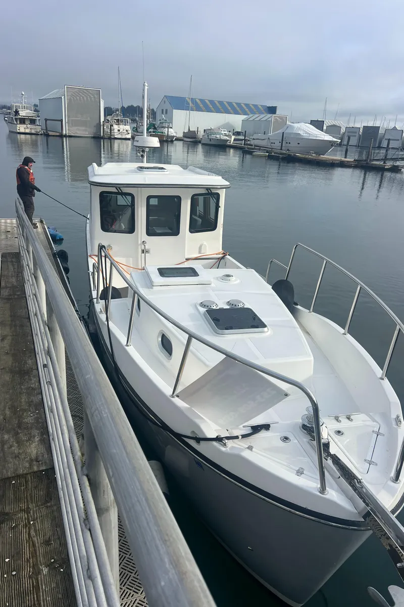Slide: The Image of 2020 SeaPiper Pilothouse boat docked at a marina with a person on the pier. - 4