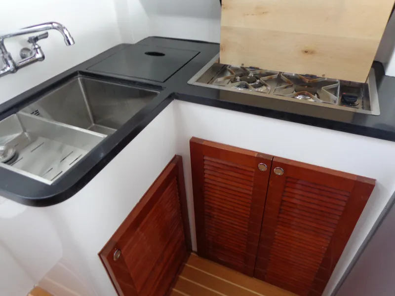 Slide: The Image of 2020 SeaPiper Pilothouse kitchen with stainless steel sink and wooden cabinets. - 40