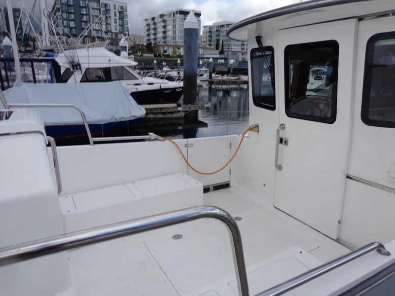 Slide: The Image of 2020 SeaPiper Pilothouse boat docked at marina with modern buildings in background. - 42
