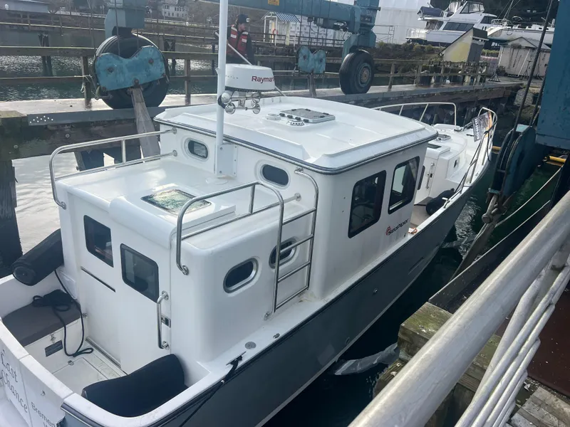 Slide: The Image of 2020 SeaPiper Pilothouse boat docked at a marina, featuring a sleek white design. - 46