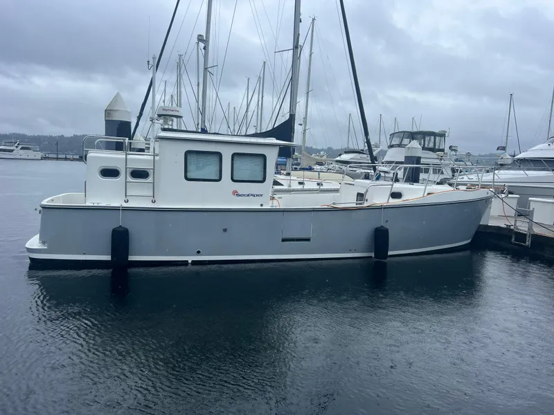 Slide: The Image of 2020 SeaPiper Pilothouse boat docked in a marina on a cloudy day. - 5