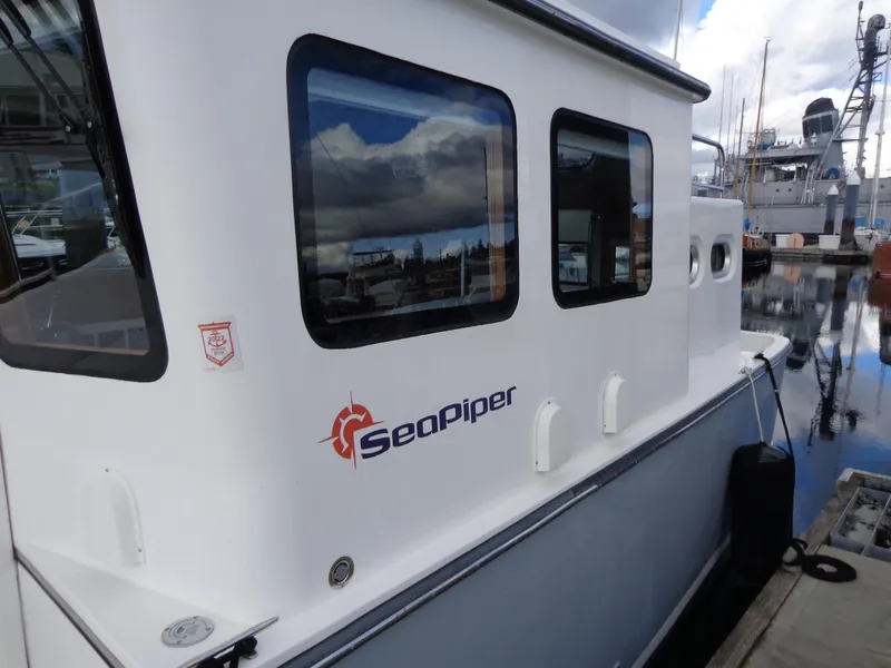 Slide: The Image of 2020 SeaPiper Pilothouse boat docked at marina, reflecting cloudy sky. - 7