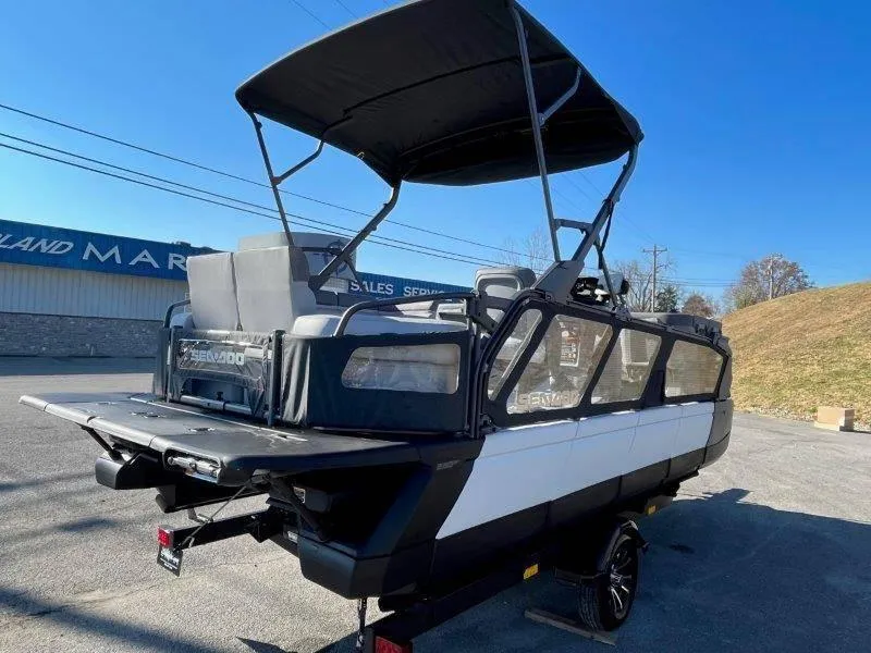 Slide: The Image of 2024 Sea-Doo Switch Cruise 21' 230HP pontoon boat with canopy, parked outdoors. - 5