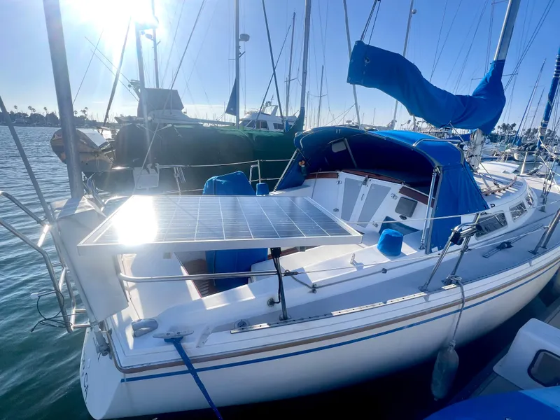 Slide: The Image of 1983 Catalina 36 sailboat with solar panel, docked in a sunny marina. - 11
