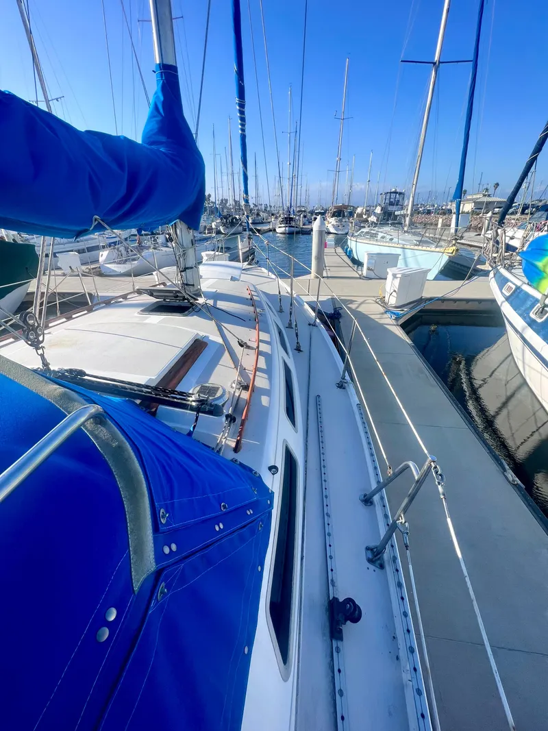 Slide: The Image of 1983 Catalina 36 sailboat docked in a marina, featuring blue sail covers. - 12