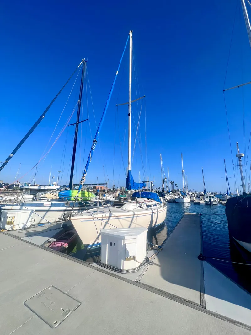 Slide: The Image of 1983 Catalina 36 sailboat docked in a sunny marina with clear blue skies. - 2