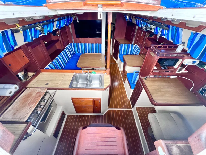 Slide: The Image of Interior of 1983 Catalina 36 sailboat with wood finishes and blue-striped upholstery. - 21