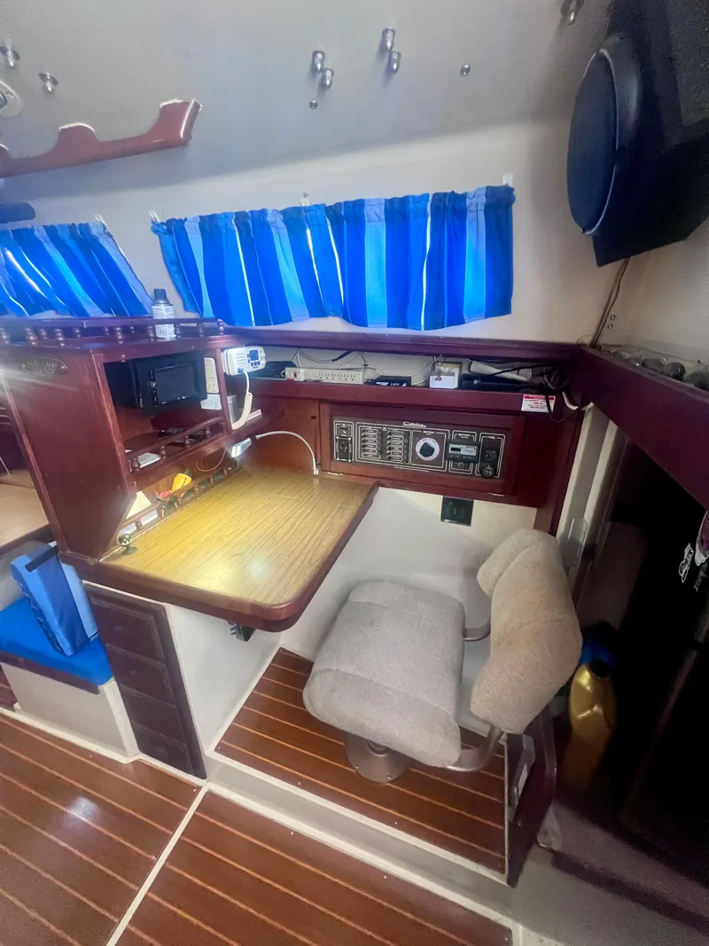Slide: The Image of Interior of 1983 Catalina 36 sailboat with navigation station and blue curtains. - 22