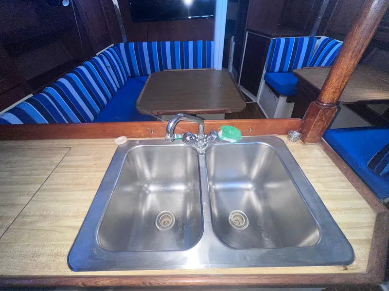 Slide: The Image of Interior of 1983 Catalina 36 sailboat with dual sink and striped seating. - 26