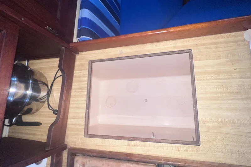 Slide: The Image of Interior of 1983 Catalina 36 sailboat showing a storage compartment and kitchen area. - 27
