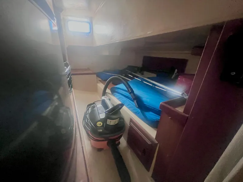 Slide: The Image of Interior of 1983 Catalina 36 sailboat cabin with vacuum cleaner and blue bedding. - 35