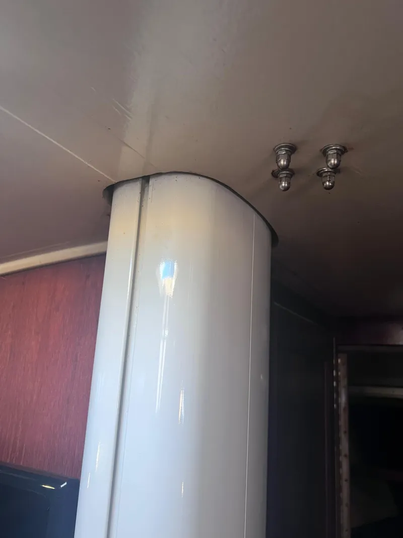 Slide: The Image of Interior view of a 1983 Catalina 36 sailboat, featuring a structural column and ceiling bolts. - 39