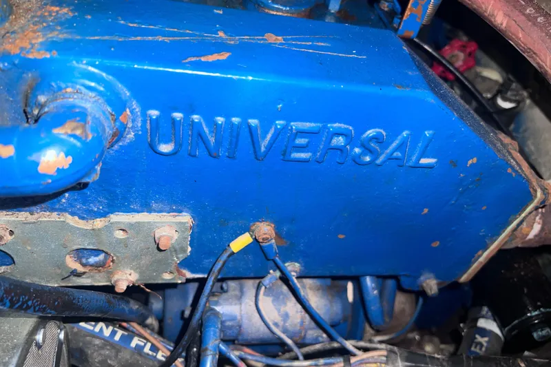 Slide: The Image of Blue Universal engine in a 1983 Catalina 36 sailboat, showing rust and wiring details. - 45