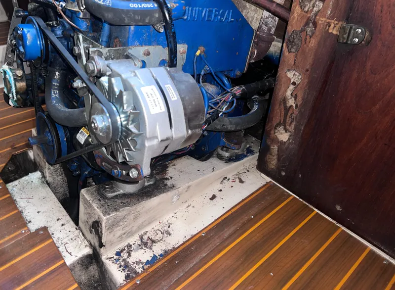 Slide: The Image of Engine compartment of a 1983 Catalina 36 sailboat, featuring a blue Universal engine. - 46