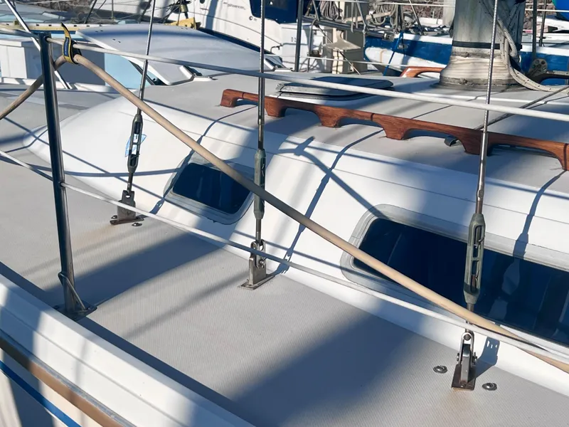 Slide: The Image of 1983 Catalina 36 sailboat deck with rigging and handrails in a marina setting. - 5
