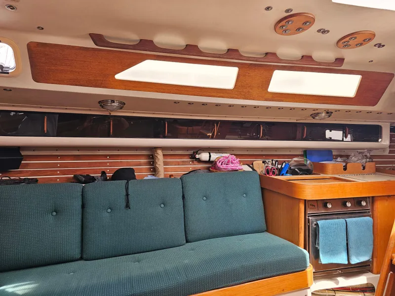 Slide: The Image of Interior of 1987 Express 37 sailboat with teal seating and wooden cabinetry. - 10