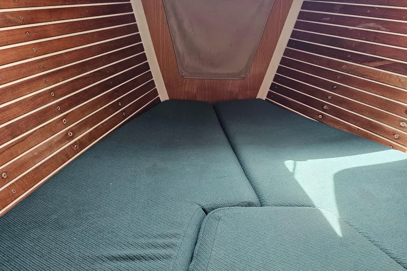 Slide: The Image of Cozy cabin interior of 1987 Express 37 sailboat with wooden paneling and cushioned bedding. - 11