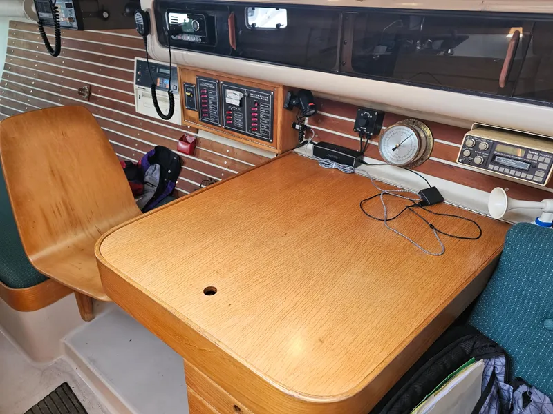 Slide: The Image of Navigation station inside 1987 Express 37 sailboat with wooden desk and communication equipment. - 13