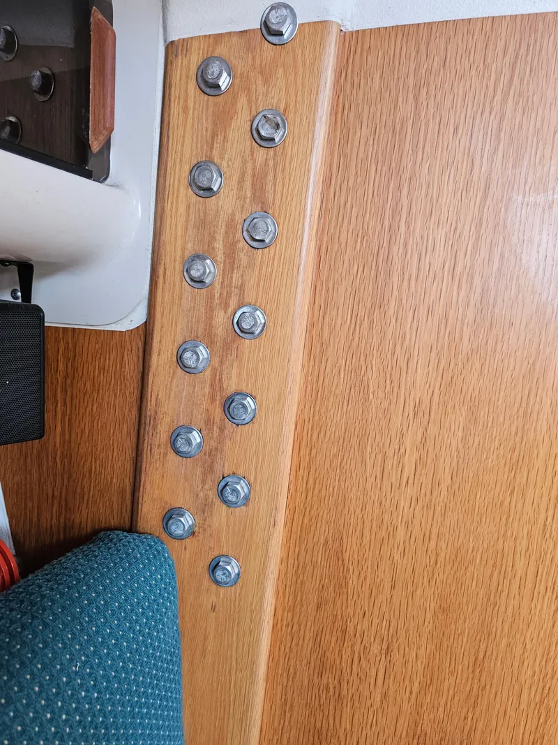Slide: The Image of Interior view of 1987 Express 37 sailboat, featuring wooden panel with metal bolts. - 19