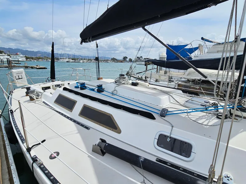Slide: The Image of 1987 Express 37 sailboat docked at marina, featuring sleek design and rigging. - 2