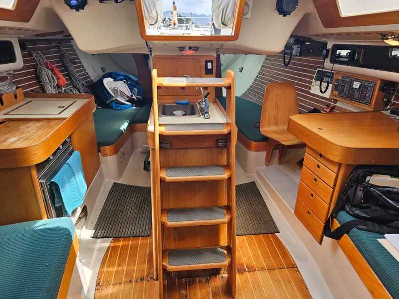 Slide: The Image of Interior of a 1987 Express 37 sailboat, featuring wooden cabinetry and seating. - 7