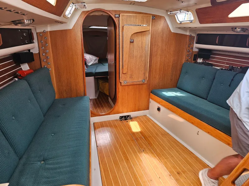 Slide: The Image of Interior of 1987 Express 37 sailboat with wood paneling and teal seating. - 8