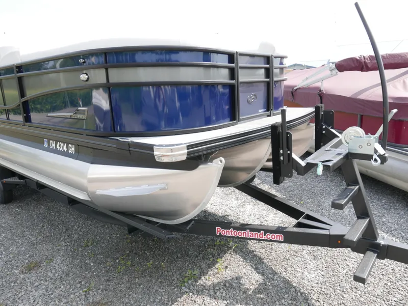 Slide: The Image of 2022 Barletta Corsa 23UC pontoon boat on trailer, displayed outdoors. - 2