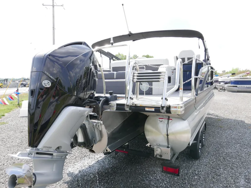 Slide: The Image of 2022 Barletta Corsa 23UC pontoon boat with powerful outboard motor, parked on gravel. - 3