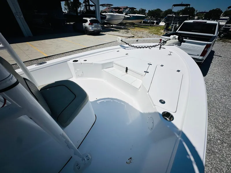 Slide: The Image of 2021 Sportsman Tournament 214 SBX Bay Boat, white deck, parked on gravel lot. - 19