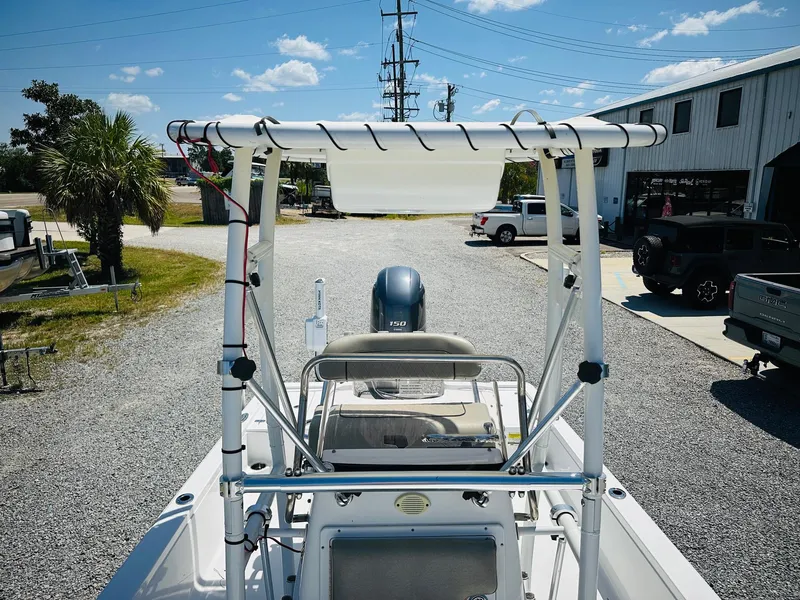Slide: The Image of 2021 Sportsman Tournament 214 SBX Bay Boat with T-top, parked outdoors on gravel. - 21