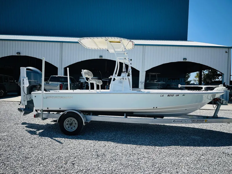 Slide: The Image of 2021 Sportsman Tournament 214 SBX Bay Boat on trailer, parked outside a large building. - 5