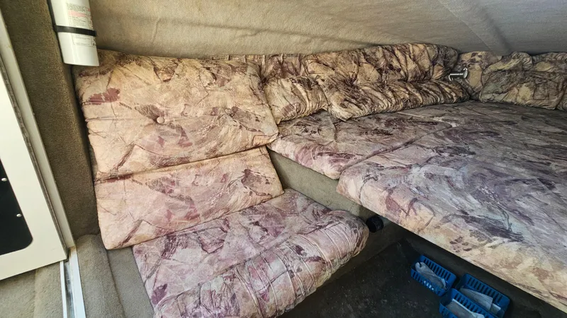 Slide: The Image of 2001 Reinell 240 C cabin interior with patterned upholstery and seating area. - 14